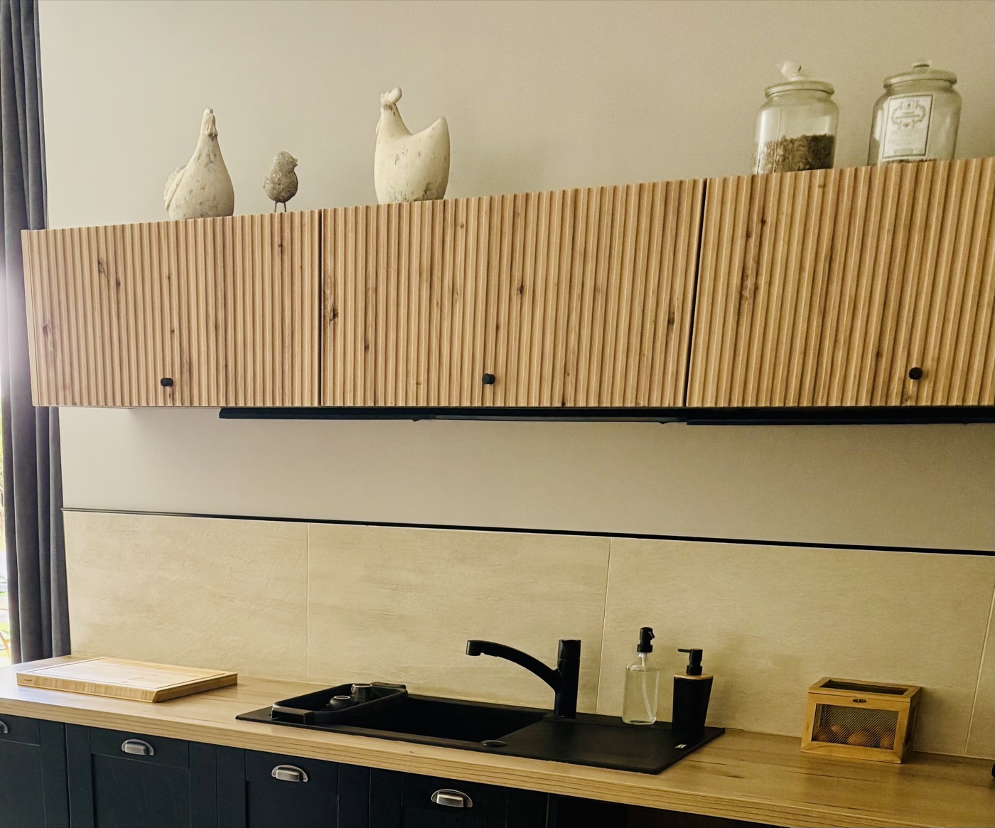 Cuisine aux façades en bois cannelé et objets décoratifs chinés